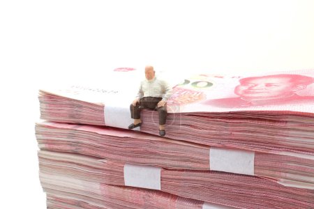 Foto de Hombre sentarse en pilas de billetes de Yuan chino - Imagen libre de derechos