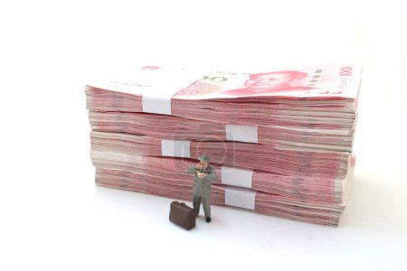 Foto de Un hombre de negocios de pie en pilas de billetes de Yuan chino, - Imagen libre de derechos