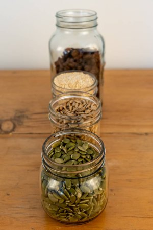 Foto de Semillas en frascos de vidrio en una encimera de cocina de madera. - Imagen libre de derechos