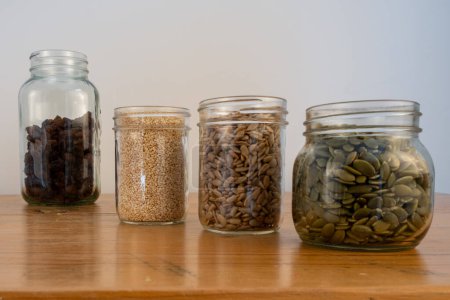 Foto de Semillas en frascos de vidrio en una encimera de cocina de madera. - Imagen libre de derechos