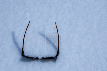 Sunglasses fallen into the snow.
