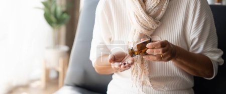 Photo for Close up mature woman taking out pills from bottle, supplements or antibiotic, older female preparing to take emergency medicine, chronic disease, healthcare and treatment concept. - Royalty Free Image