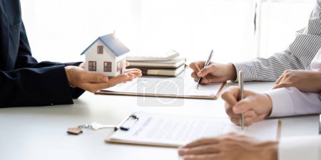 Téléchargez les photos : Agent immobilier avec couple conclusion d'un accord et signature d'un contrat - en image libre de droit