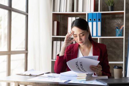 Foto de Asian business woman got stressed at work during in the office room, unhappy face while working. - Imagen libre de derechos