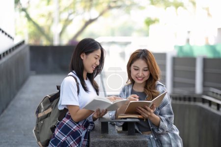Foto de Alegre asiática universidad dos mujeres estudiantes están hablando, compartir ideas, trabajando en su escuela proyecto juntos. - Imagen libre de derechos