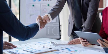 Photo for Shaking hand business leaders talk about charts, financial graphs showing results are analyzing and calculating planning strategies, business success building processes. - Royalty Free Image