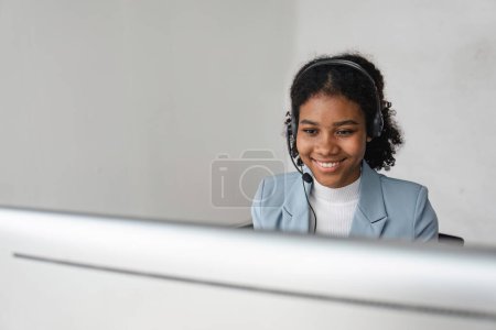 Photo for Portrait of happy smiling female customer support phone operator at workplace. Smiling beautiful African American woman working in call center. - Royalty Free Image