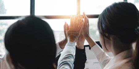 Photo for Group of business diversity workers standing with hands together high five at the office. - Royalty Free Image