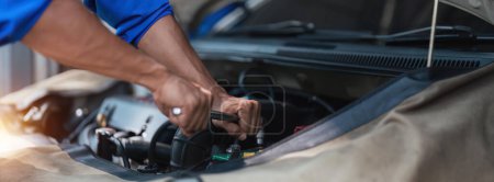Foto de Técnico de cerca utiliza voltímetro multímetro para comprobar el nivel de voltaje en la batería del coche. Servicio y mantenimiento de la batería del coche.. - Imagen libre de derechos