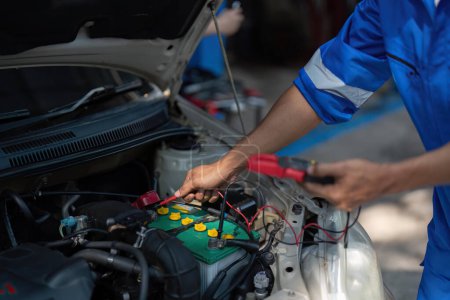Photo for Close up technician uses multimeter voltmeter to check voltage level in car battery. Service and Maintenance car battery.. - Royalty Free Image