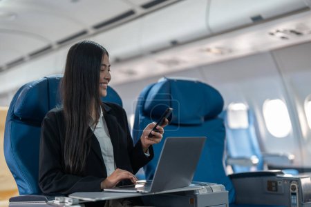Foto de Transporte, turismo y tecnología concepto de mujer de negocios con teléfono inteligente y portátil que viaja en avión. - Imagen libre de derechos
