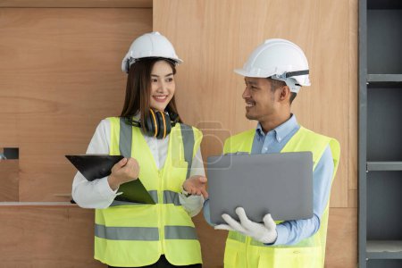 Photo for Engineer construction and in vest with helmet working with laptop, standing on building construction site. Home building project. Engineer discusses with coworker at workplace. - Royalty Free Image