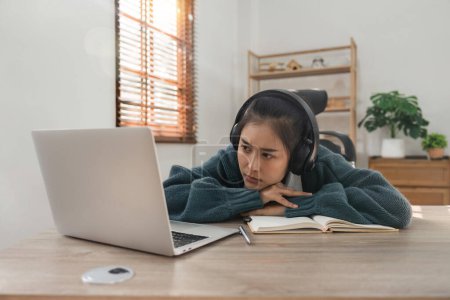 Photo for Bored young asian girl student studying, looking upset at laptop screen, attend boring online classes or lecture. Tired bored lazy. - Royalty Free Image