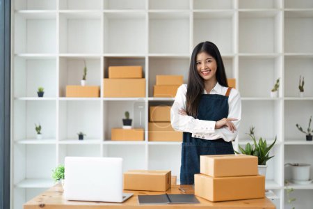 Photo for Young pretty asian start up business woman in apron working with online parcel box warehouse selling online product. - Royalty Free Image
