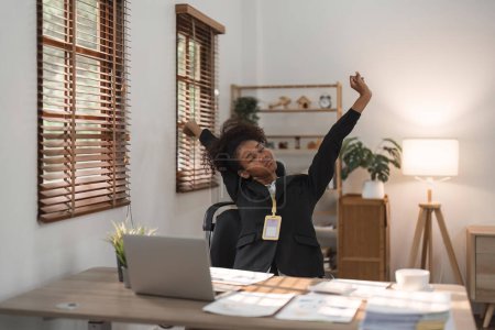 Foto de Negro mujer de negocios se extiende en la oficina en el lugar de trabajo. - Imagen libre de derechos