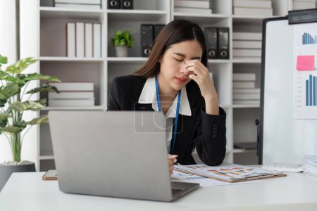 Foto de Mujer de negocios están estresados mientras se trabaja en el ordenador portátil cansado de dolor de cabeza en la oficina, sentirse mal en el trabajo. - Imagen libre de derechos