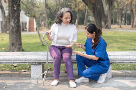 Foto de Enfermera dando medicina a la mujer mayor en el parque del hospital, Mantenimiento. - Imagen libre de derechos