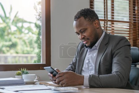 Foto de Hombre de negocios leyendo un correo electrónico en un teléfono inteligente y redes sociales mientras trabaja en la oficina. - Imagen libre de derechos