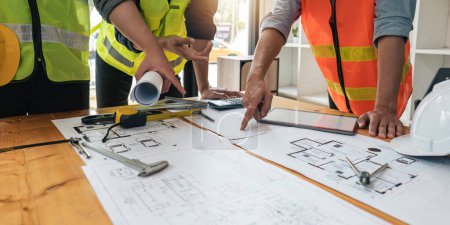 Photo for Engineer people meeting working and pointing at a blueprint in office for discussing. Engineering tools and construction concept. - Royalty Free Image