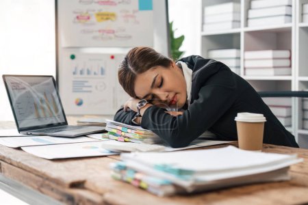 Foto de Mujer de negocios cansada somnolienta y aburrida de sentarse en un escritorio durante mucho tiempo y tiene síndrome de oficina. - Imagen libre de derechos