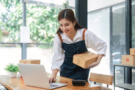 Téléchargez les photos : Business From Home Asian woman preparing package delivery box Shipping for shopping online. young start up small business owner at home online order. - en image libre de droit