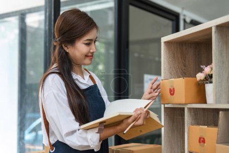 Foto de Business From Home Asian woman preparing package delivery box Shipping for shopping online. young start up small business owner at home online order. - Imagen libre de derechos