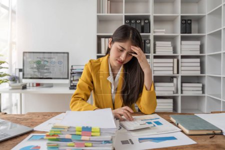 Photo for Business women are stressed while working on laptop and pile of documents, Tired businesswoman with headache at office, feeling sick at work. - Royalty Free Image