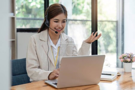 Photo for Call center agent with headset working on support hotline in modern office. Video conference. - Royalty Free Image