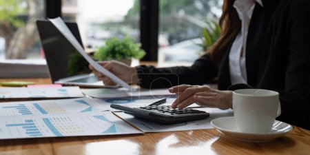 Geschäftsfrau arbeitet am Schreibtisch Büro mit einem Taschenrechner, um die Zahlen zu berechnen, Finanzbuchhaltungskonzept.