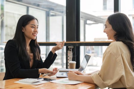 Photo for Happy two beautiful young Asian businesswoman standing discuss working together at office. - Royalty Free Image
