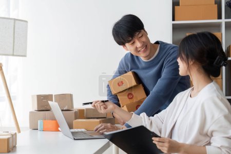 Photo for Couple startup small business working with laptop at workplace. freelance man and woman seller check product order, packing goods for delivery to customer. Online selling, e-commerce. - Royalty Free Image