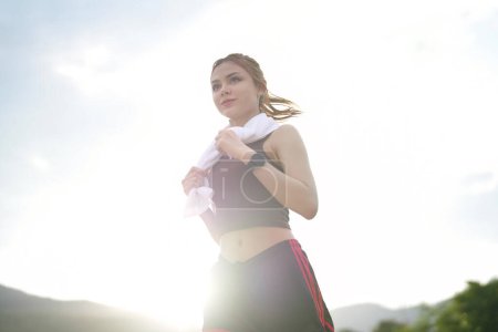 Téléchargez les photos : Jeune belle coureuse athlétique attrayante court dans le parc vert jogging. Concept de mode de vie sain et actif. - en image libre de droit