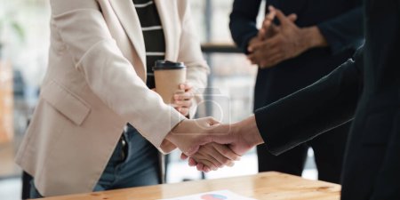 Photo for End of meeting handshake of two happy businessmen after a contract agreement to be a team collaboration partnership. Colleagues applaud. - Royalty Free Image