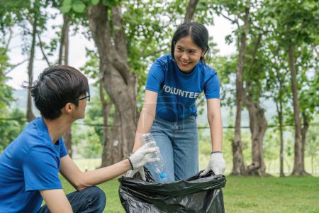 Photo for Cropped view of young volunteers collecting trash in the park. Trash bins in the park. Ecology group. Environmental protection concept. Team with recycling project outside. - Royalty Free Image