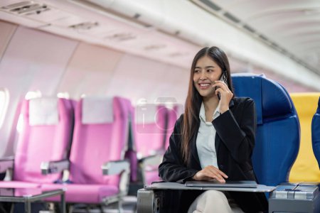 Foto de Joven asiática sentada con teléfono en el avión durante el vuelo en el avión. - Imagen libre de derechos
