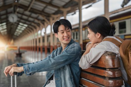 Photo for Asian couple travelers, backpack travelers, together at train station platform. tourism activity or railroad trip traveling concept. - Royalty Free Image