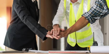 Photo for Construction workers, architects and engineers shake hands after completing an agreement in an office facility, successful cooperation concept. - Royalty Free Image