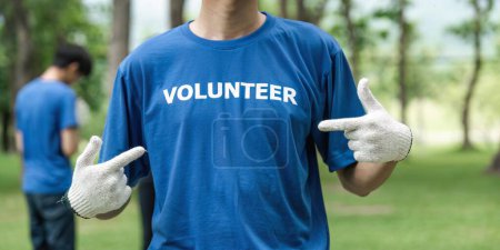 Primer plano joven voluntario usando camiseta con mensaje de voluntariado.