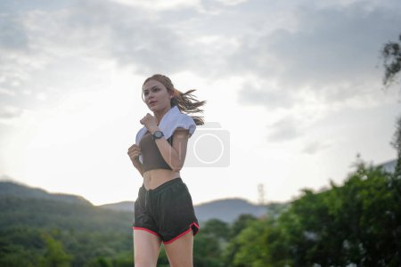 Photo for Portrait of young woman running in the city park in the early morning. - Royalty Free Image