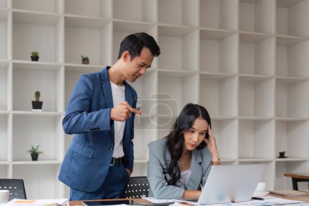 Photo for Two business people being stressed while working on a laptop in an office, Business partners working together, Collaborating teamwork analyzing paperwork data, business reports. - Royalty Free Image