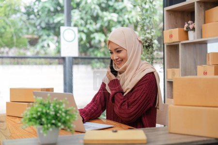 Foto de Hermosa mujer musulmana vendiendo en línea en casa, dueño de un negocio, conceptos de negocios sme. - Imagen libre de derechos