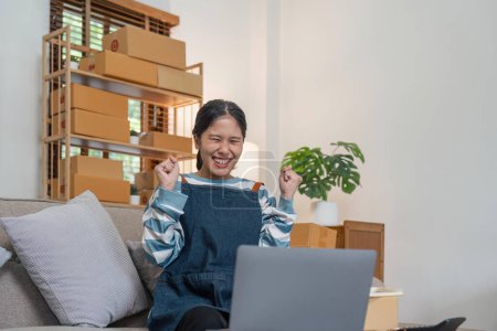 Téléchargez les photos : Les femmes asiatiques réussissent grâce à la croissance des ventes. Femmes heureuses vendant des produits en ligne avec ordinateur portable. Belle jeune femme propriétaire d'entreprise sur les affaires en ligne. - en image libre de droit