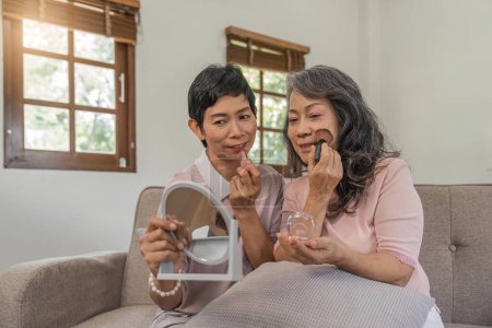Foto de Mujeres bastante mayores aplicando maquillaje sosteniendo pequeños espejos, viejos amigos felices
. - Imagen libre de derechos