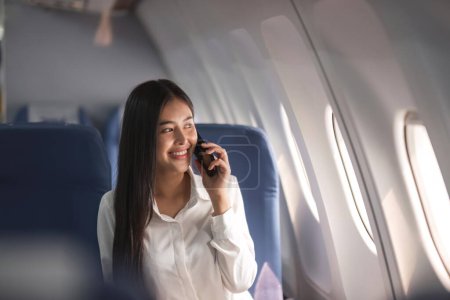 Photo for Young plane passenger business woman using smartphone communicate, businesswoman working while flying at plane. - Royalty Free Image