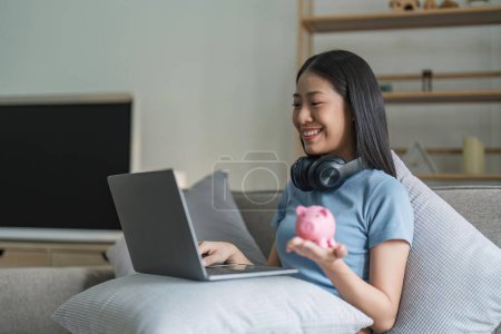 Téléchargez les photos : Young woman using laptop for shopping or analyzing home finances. - en image libre de droit