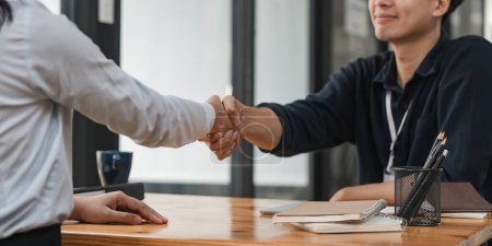 Photo for Pretty asian business woman shaking hands with businessman in her office during meeting. - Royalty Free Image