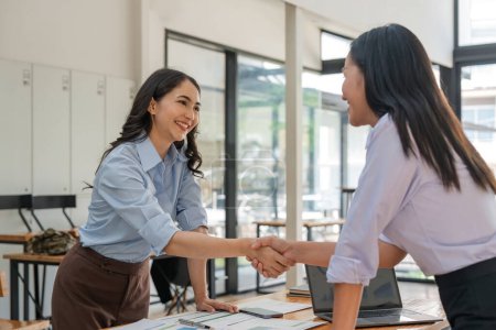 Photo for Portrait young asian business woman e shaking hands a meeting in the office success. Business people handshake in modern office. Greeting deal concept. - Royalty Free Image