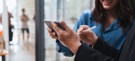 Foto de Gente inteligente de negocios que trabaja junto con la tableta mientras habla en el lugar de coworking. - Imagen libre de derechos