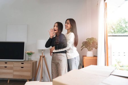Photo for Homosexual happy young Asian woman hug girlfriend after moving stuff to a new rent house. - Royalty Free Image