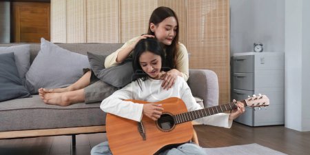 Photo for Homosexual LGBT young women playing guitar and singing in living room with happiness moment. - Royalty Free Image
